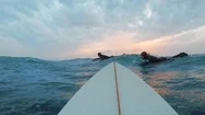 Two Cold Water Surfers Are Passing By A Surfer In The Sunset Stock Footage