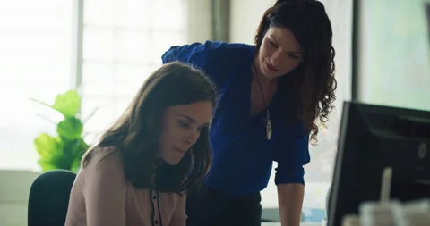 Two collaborative business women work together on documents in modern office dur Stock Footage 199463287