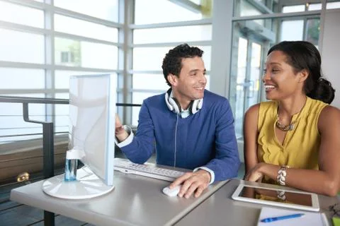 Two  colleages discussing ideas using a tablet and computer Stock Photos