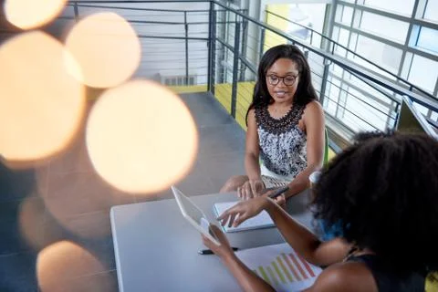 Two  colleages discussing ideas using a tablet and computer Stock Photos