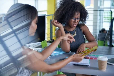 Two  colleages discussing ideas using a tablet and computer Stock Photos
