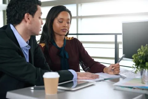 Two  colleages discussing ideas using a tablet and computer Stock Photos