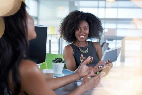 Two  colleages discussing ideas using a tablet and computer Stock Photos