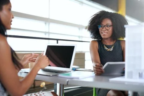 Two  colleages discussing ideas using a tablet and computer Stock Photos