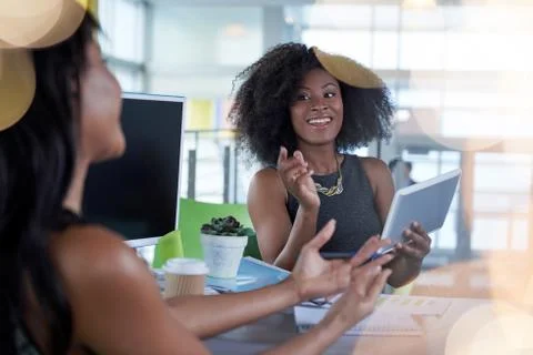 Two  colleages discussing ideas using a tablet and computer Stock Photos
