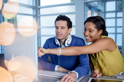 Two  colleages discussing ideas using a tablet and computer Stock Photos