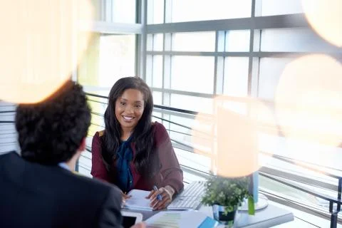 Two  colleages discussing ideas using a tablet and computer Stock Photos