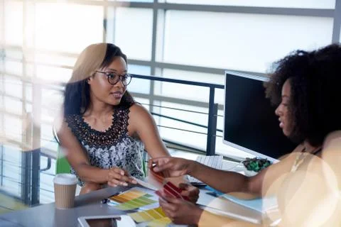 Two  colleages discussing ideas using a tablet and computer Stock Photos