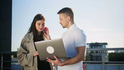 Two colleagues are looking at a new project on the roof of an office building Stock Footage 195206858