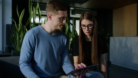 Two colleagues are working on projects on a tablet Stock Footage 246052749