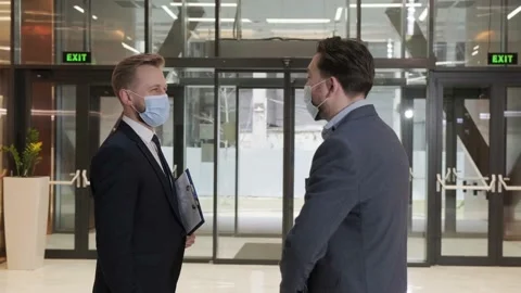 Two colleagues avoid a handshake when meeting and greet with elbows bumping. Stock Footage 150905562