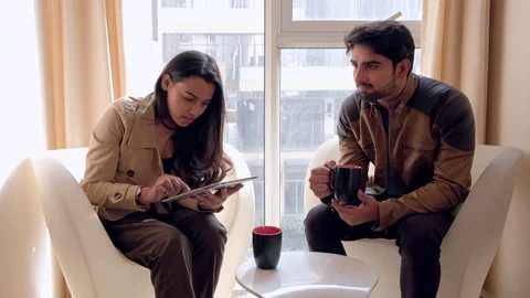 Two colleagues busy working sharing on a mobile electronic device have their att Stock Footage 101336040