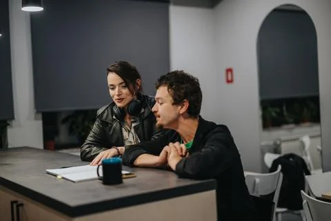 Two colleagues collaborating at a desk during a work session in a modern office 스톡 사진