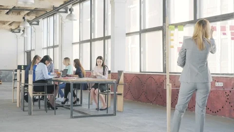 Two colleagues communicate and make a presentation on a glass board. Employees Stock Footage 109371953