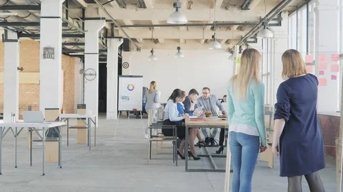 Two colleagues communicate and make a presentation on a glass board. Employees Stock Footage 109374691