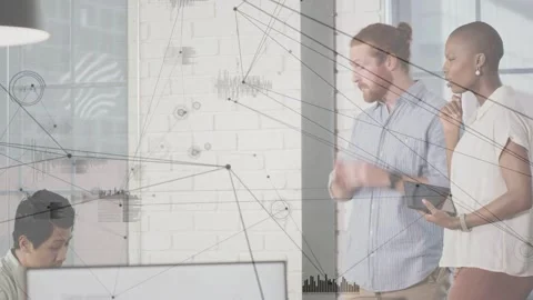 Two colleagues consulting tablet, pointing at monitor, aligning design while Stock Footage 333657445