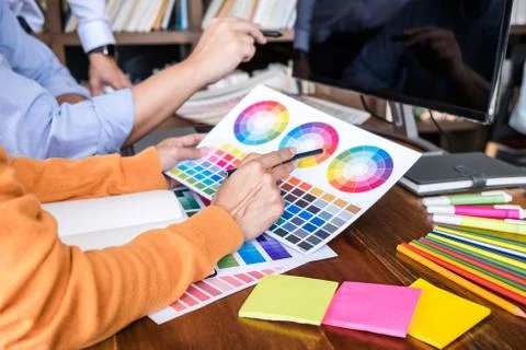 Two colleagues creative graphic designer working on color selection and drawi Stock Photos