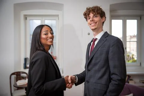 Two colleagues of different ethnicities shaking hands, concept of found agr.. Stock Photos