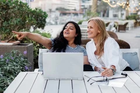 Two colleagues discuss a common project while working together outside the Stock Photos