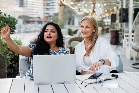 Two colleagues discuss a common project while working together outside the Stock Photos