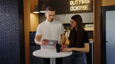 Two colleagues discuss a new project during a coffee break in the office Stock Footage 219460850