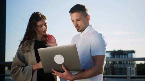 Two colleagues discuss a new project on the roof of an office building Stock Footage 246052524