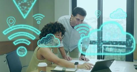 Two colleagues discussing cloud computing in meeting room with laptop, papers 스톡 사진