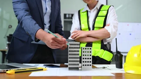 Two colleagues discussing data working and tablet, laptop with architectura.. Stock Footage 312775097
