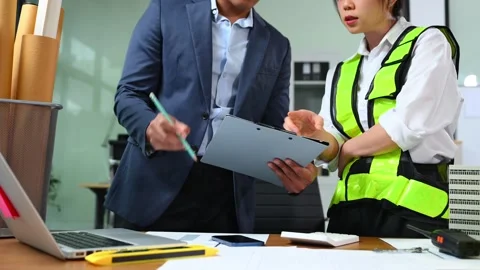 Two colleagues discussing data working and tablet, laptop with architectura.. Stock Footage 312775125