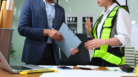 Two colleagues discussing data working and tablet, laptop with architectura.. Stock Footage 312775163