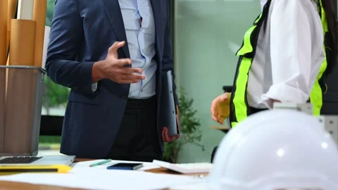Two colleagues discussing data working and tablet, laptop with architectura.. Stock Footage 312775184