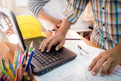 Two colleagues discussing data working with construction plan. Stock Photos