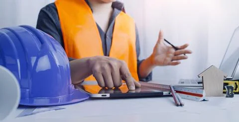 Two colleagues discussing data working and tablet, laptop with on on archit.. Stock Photos