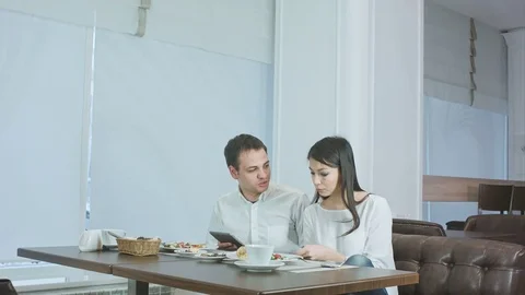 Two colleagues discussing work while eating lunch in a cafe Stock Footage 72094945