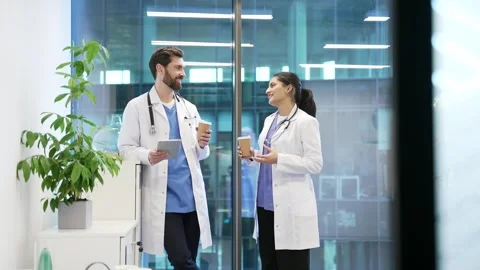 Two colleagues doctors engaged in friendly conversation with coffee in modern  Stock Footage 298996724