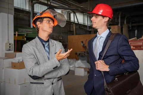 Two colleagues during a conversation at work in the factory, engineers eleg.. Stock Photos