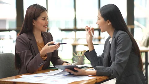 Two colleagues engaged in business analytics, using calculator over financial Stock Footage 280816190