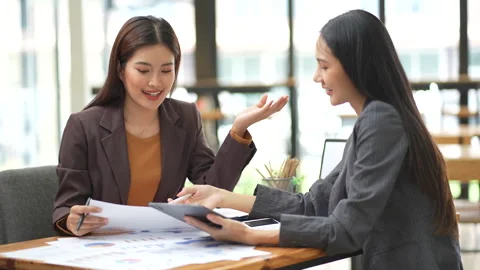 Two colleagues engaged in business analytics, using calculator over financial Stock Footage 280816206