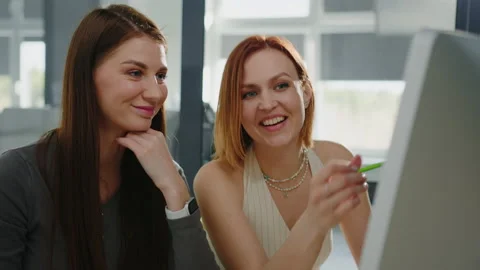 Two colleagues in front of a designer computer monitor discuss Stock Footage 232477486