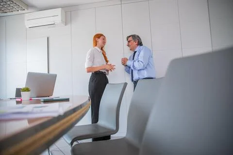 Two colleagues having conversation in office meeting room, age difference Stock Photos