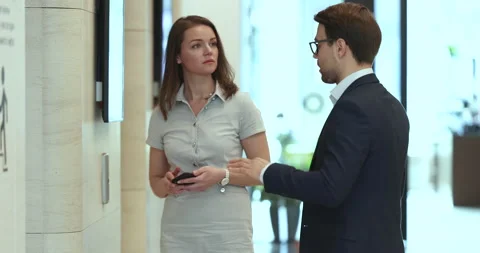 Two colleagues having conversation walking in office hallway Stock Footage 225229777