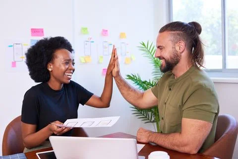 Two colleagues high five over final design of mobile app, developers coding UX Stock Photos