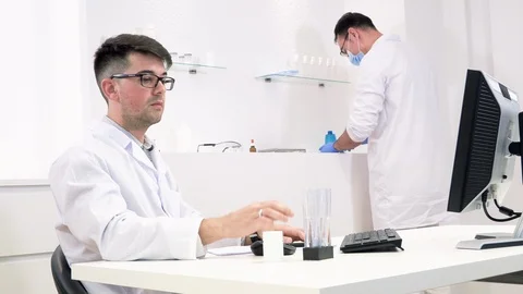 Two colleagues in a lab, one behind a computer Stock Footage 118211044
