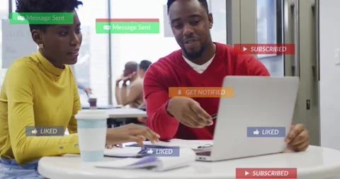 Two colleagues leaning on laptop, responding as notifications popping up, Stock Footage 332296019