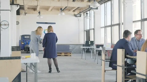 Two colleagues make a presentation on a flipchart, then take a large sheet and Stock Footage 109370637