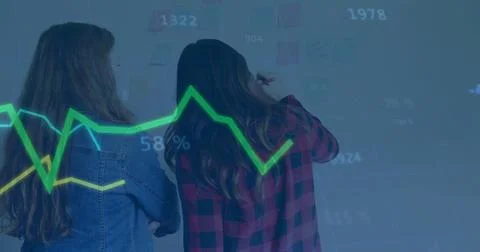 Two colleagues marking sticky notes and referencing graph in conference room, Stock Photos