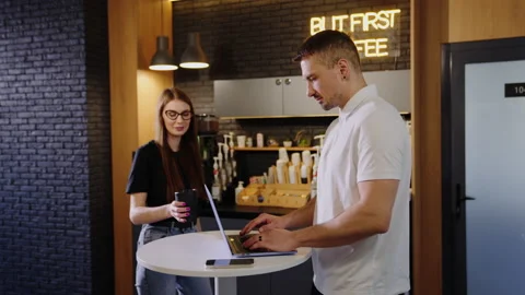 Two colleagues met at the office cafe point. A man is working on a laptop Stock Footage 201921058