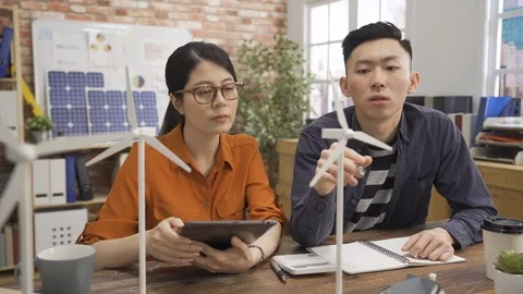Two colleagues in office discussing windmill Video stock 112116738