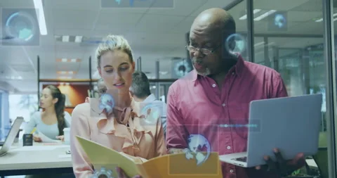 Two colleagues opening folder and pointing while animating UI charts and maps Stock Footage 315609439