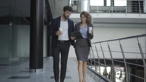 Two colleagues positive talking and working together at workplace where all is Video stock 131047162